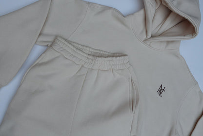Woman's Mini & Me - Beige Butter Soft Trackies: Laid-flat loungewear set featuring a hooded sweatshirt with embroidered logo and matching sweatpants with elastic waistband and side pockets.