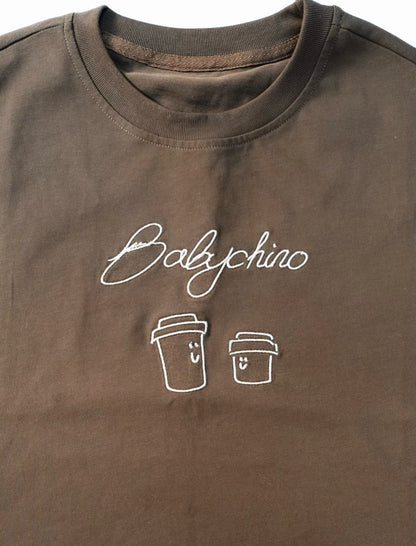 Babychino Tee featuring Babychino embroidery and smiling coffee cup designs, crafted from 100% cotton, offering an oversized fit for casual coffee outings.